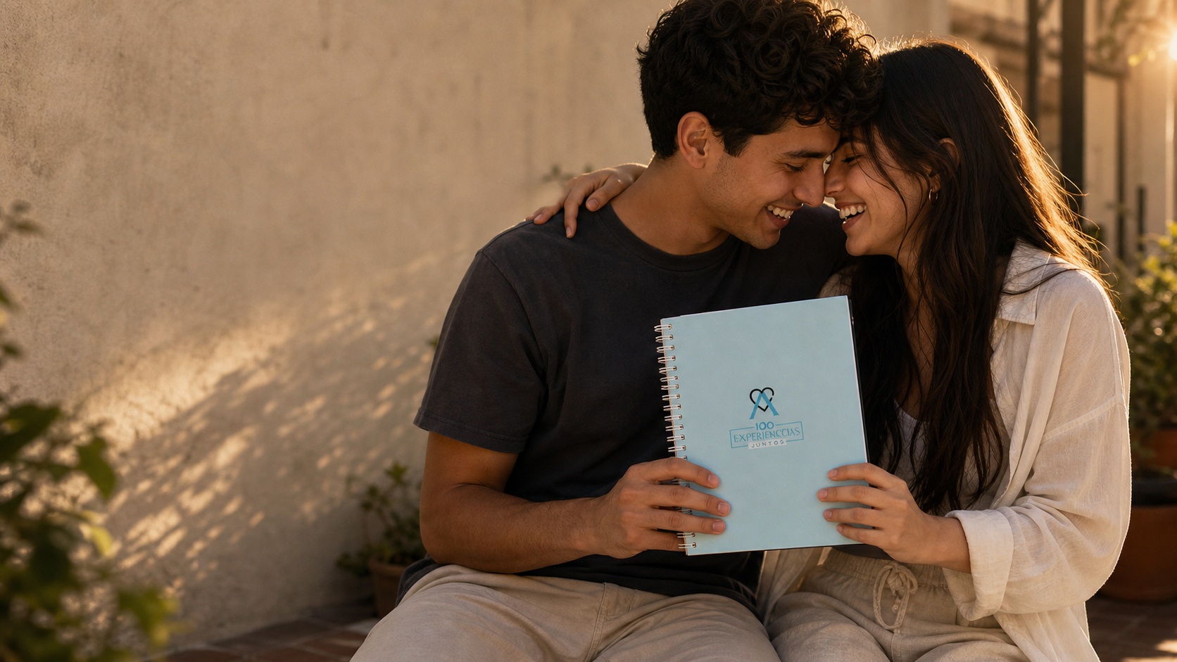 Pareja frente con frente sonriendo con el álbum bajo luz dorada